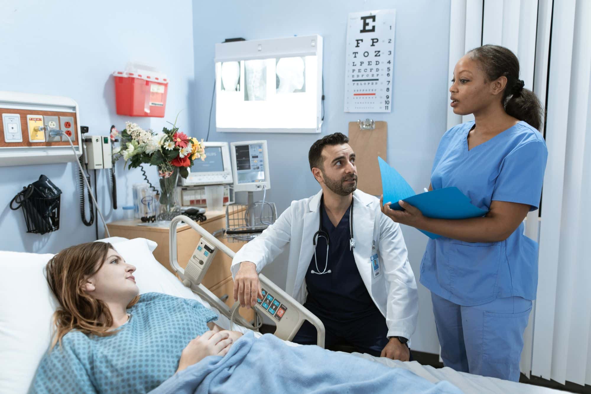 Physician and nurse with a patient in a community hospital room