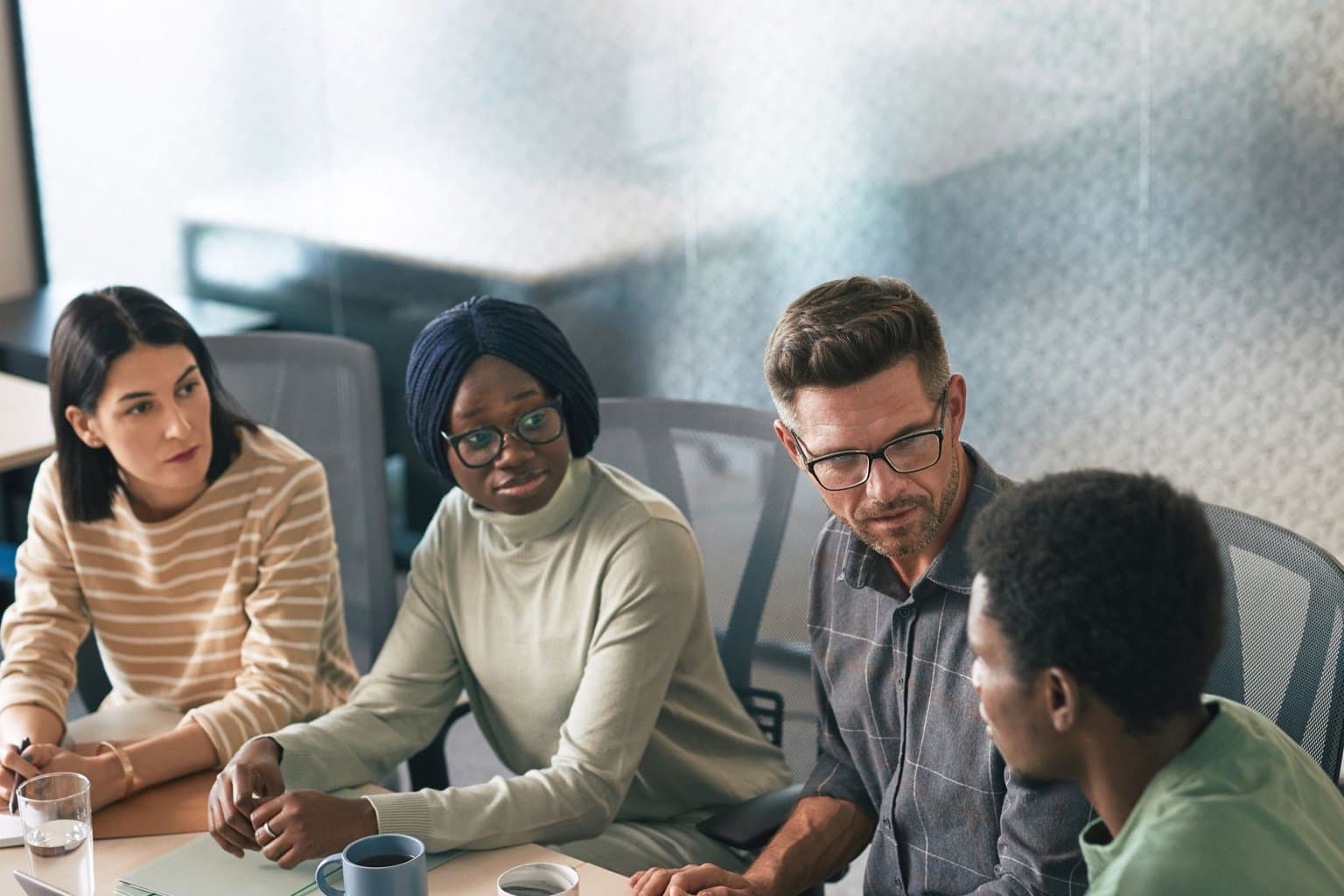 Nonprofit leadership team in a planning conversation around a conference table before a capital campaign