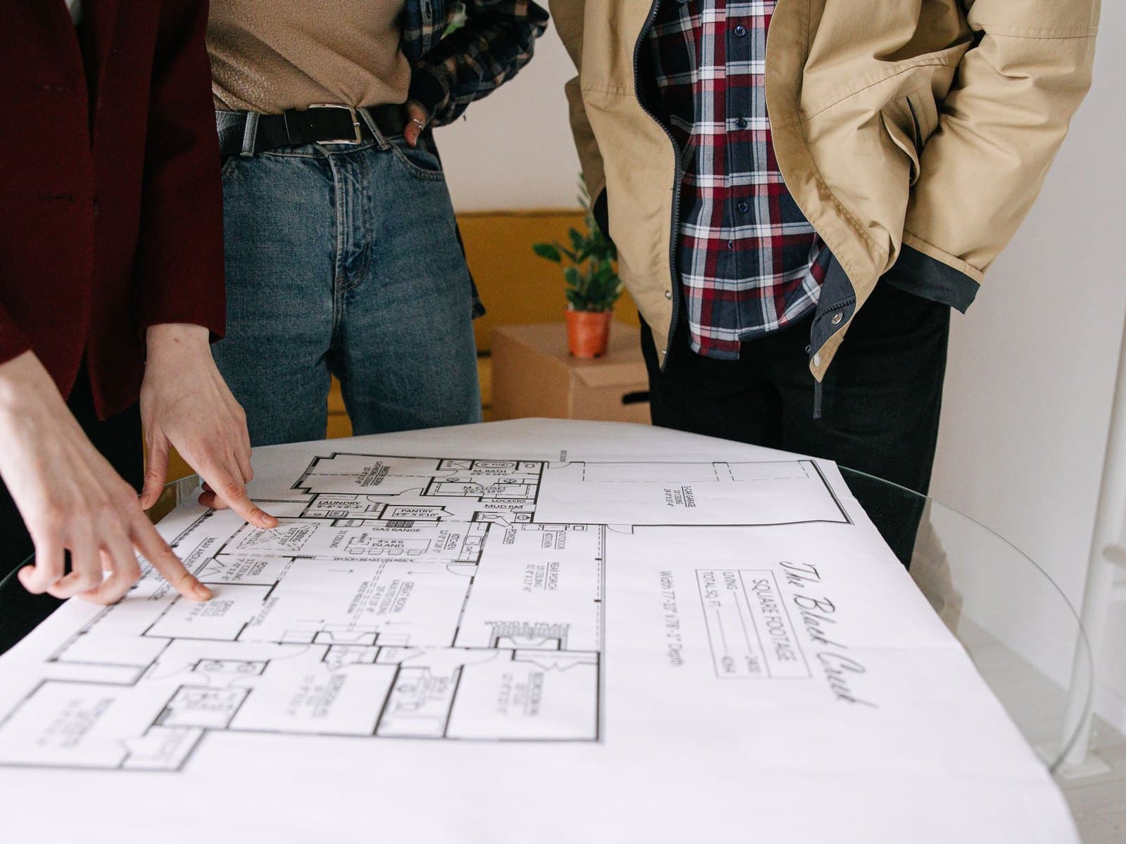 Three people leaning over architectural plans for a new building