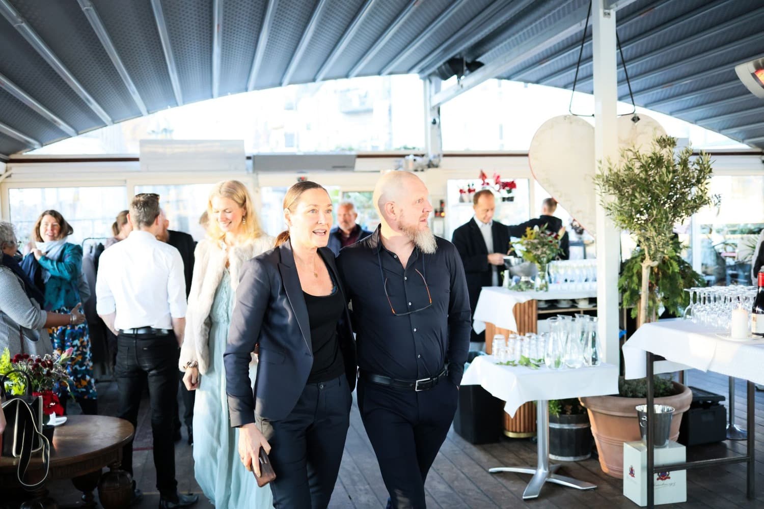 Guests mingling at an indoor reception with refreshments and event staff