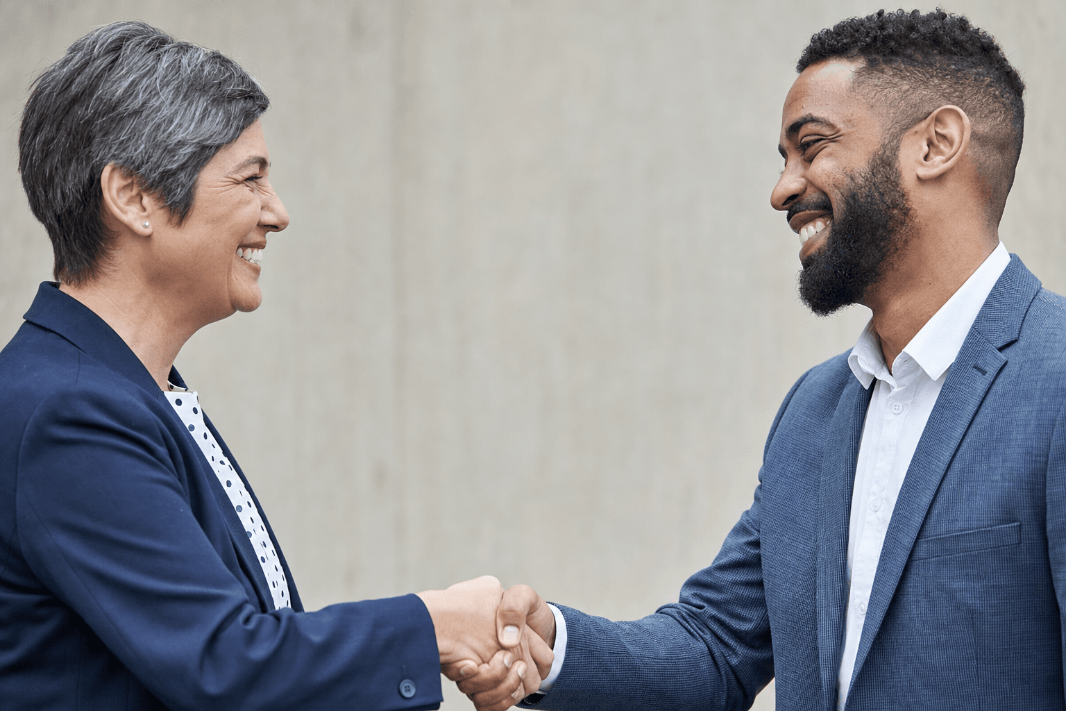 Two professionals shaking hands after a successful major gift solicitation meeting